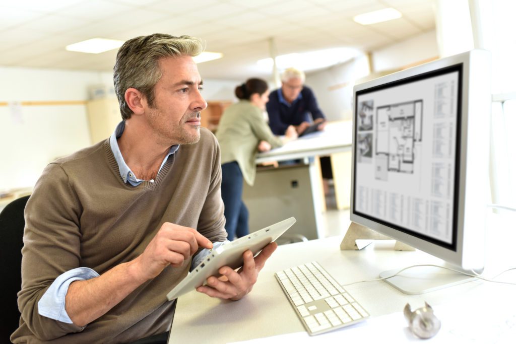 Engineer working on a design with a desktop computer.