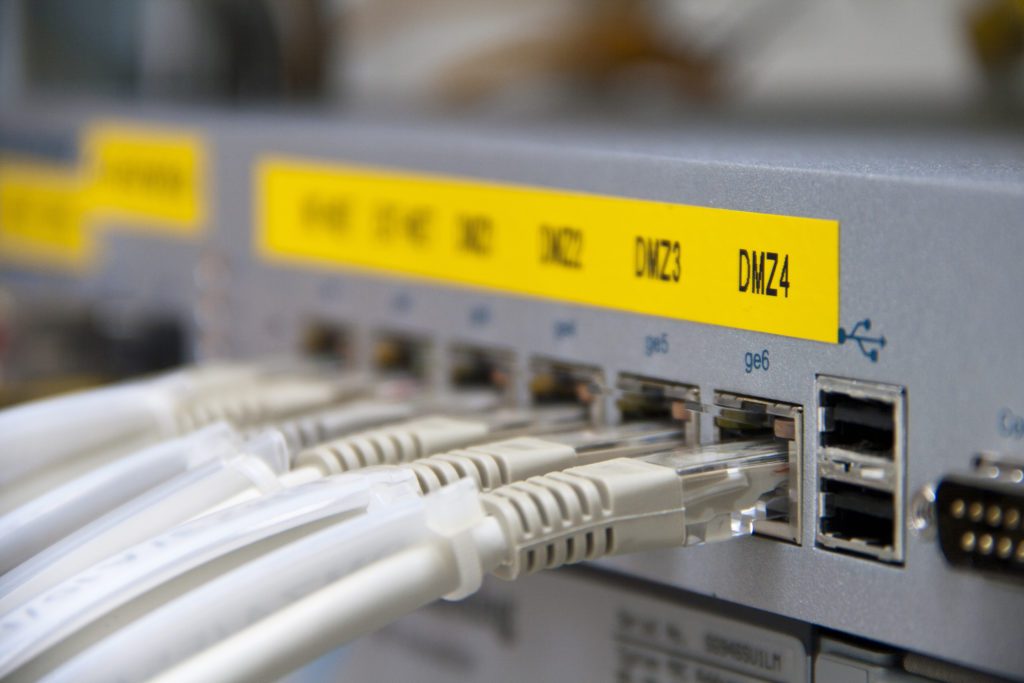 Ethernet cables connected to a firewall demonstrating dmz vs port forwarding