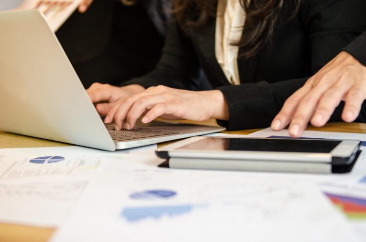 Woman typing on laptop in meeting room