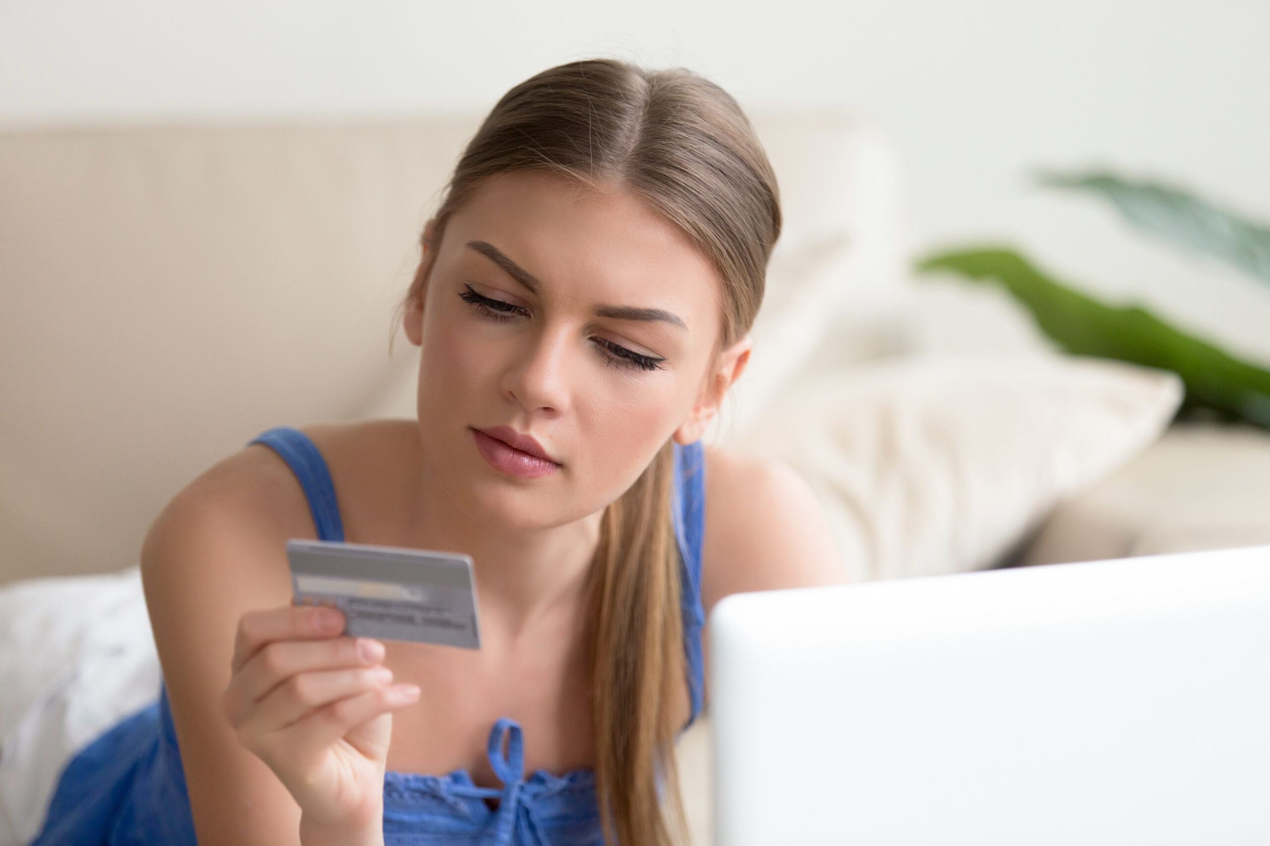 Young woman paying by credit card shopping online at home
