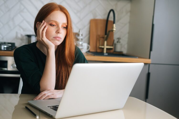 frustrated young woman while working on laptop at home.