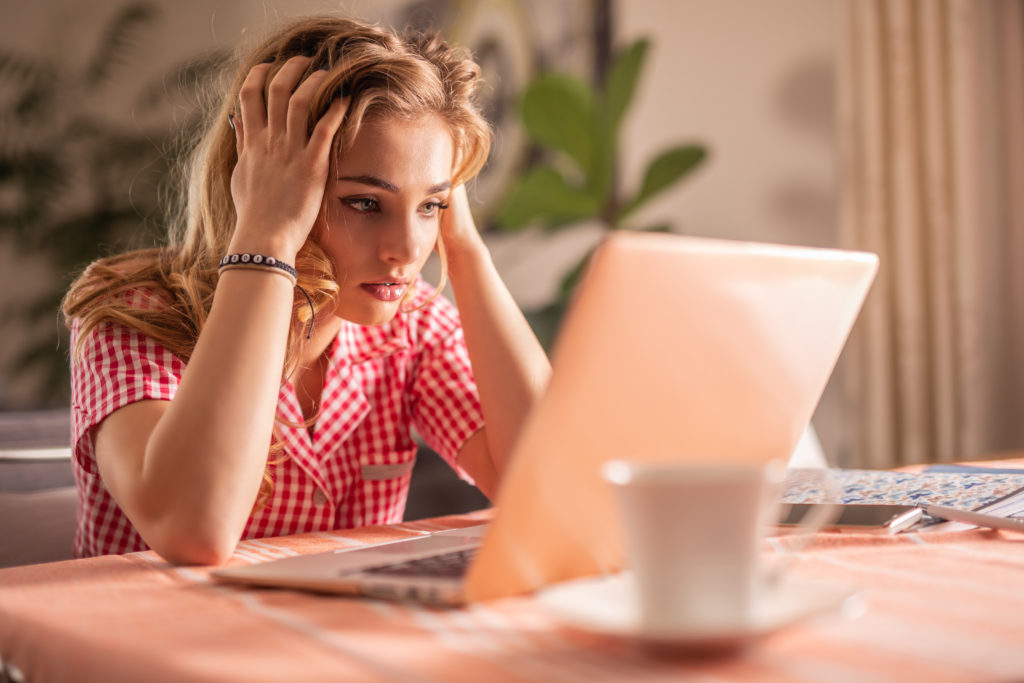 Exhausted woman working on a laptop.