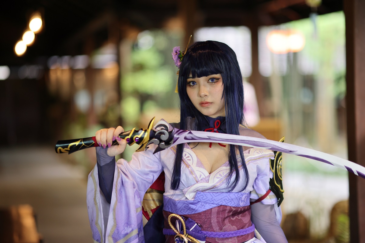 a beautiful young woman cosplayer with samurai dress costume at a Japanese garden