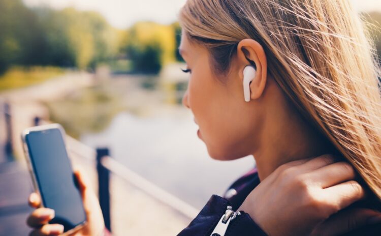 Woman holding iPhone who needs to learn what it means to optimize iphone storage to fix her phone.