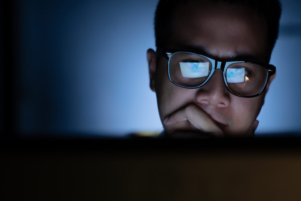 Focused man working and thinking while looking at the computer.