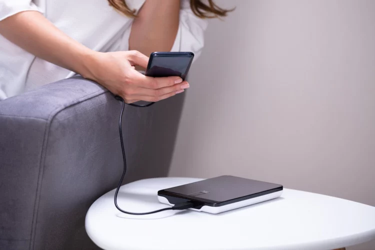 Woman charging her smartphone using power bank