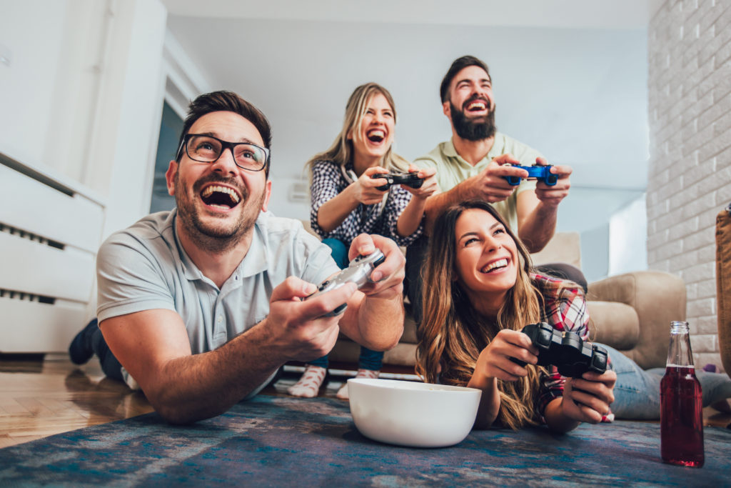 grupp vänner som spelar videospel tillsammans hemma.