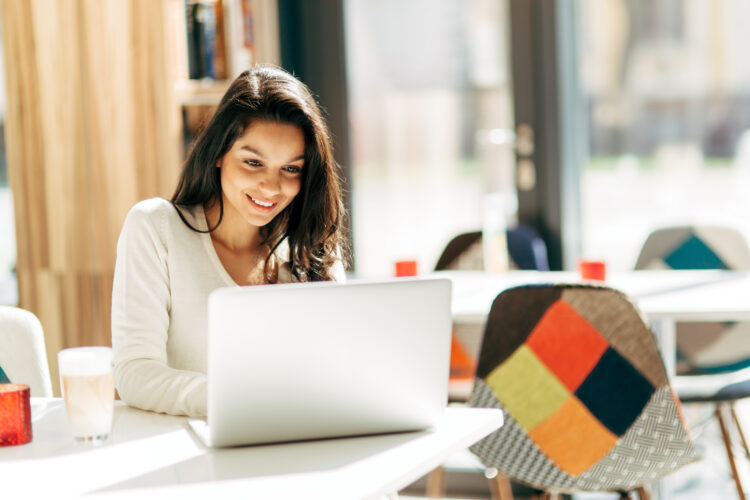 Brunette using laptop in cafe