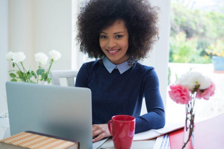 beautiful smiling woman using laptop at desk