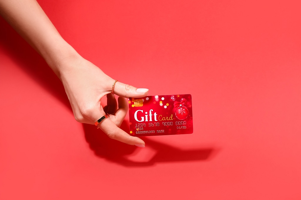 Female hand holding a red gift card.