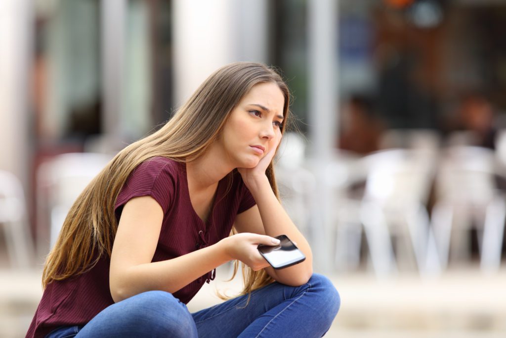 Girl waiting for a phone call in a public place.