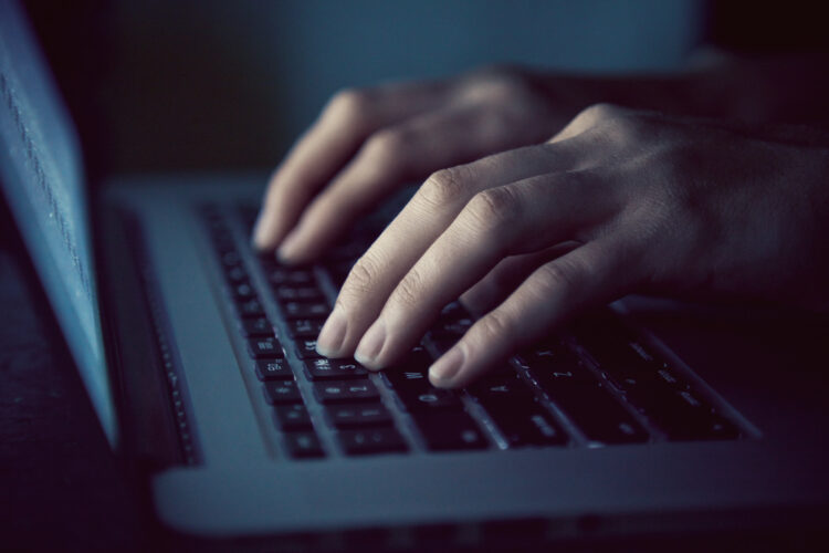 hands with laptop typing in the night