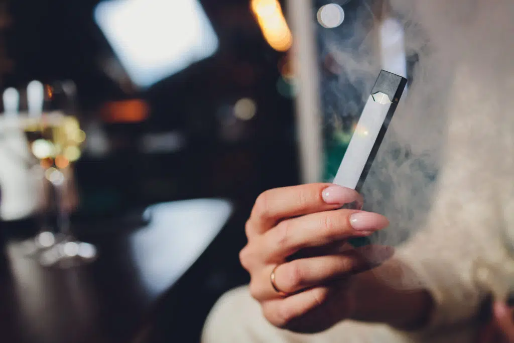 Hand holding a gray e-cigarette.