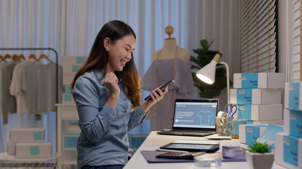 Happy entrepreneur checking her phone.