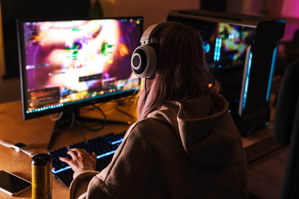 Girl playing video game on personal computer.