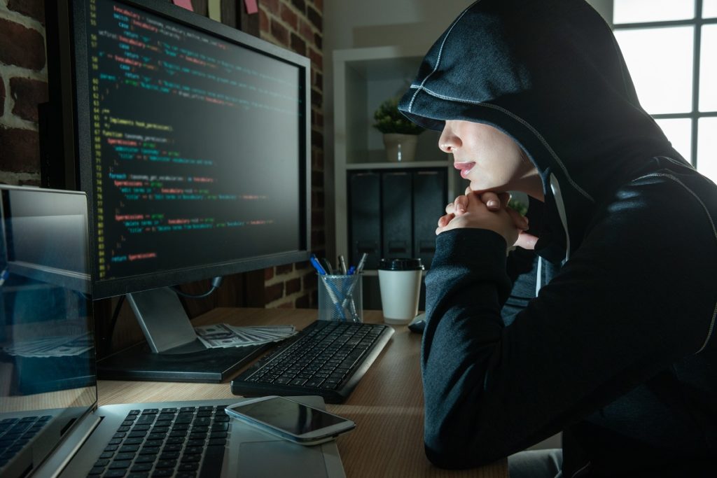 female hacker staring at the screen smiling.