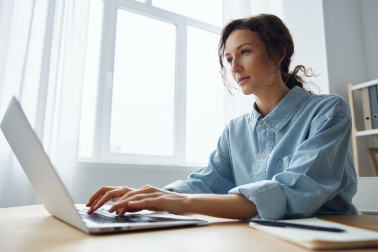 focused woman using laptop in office