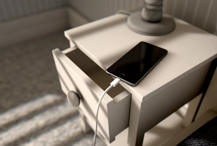 smartphone on top of drawer next to the bed