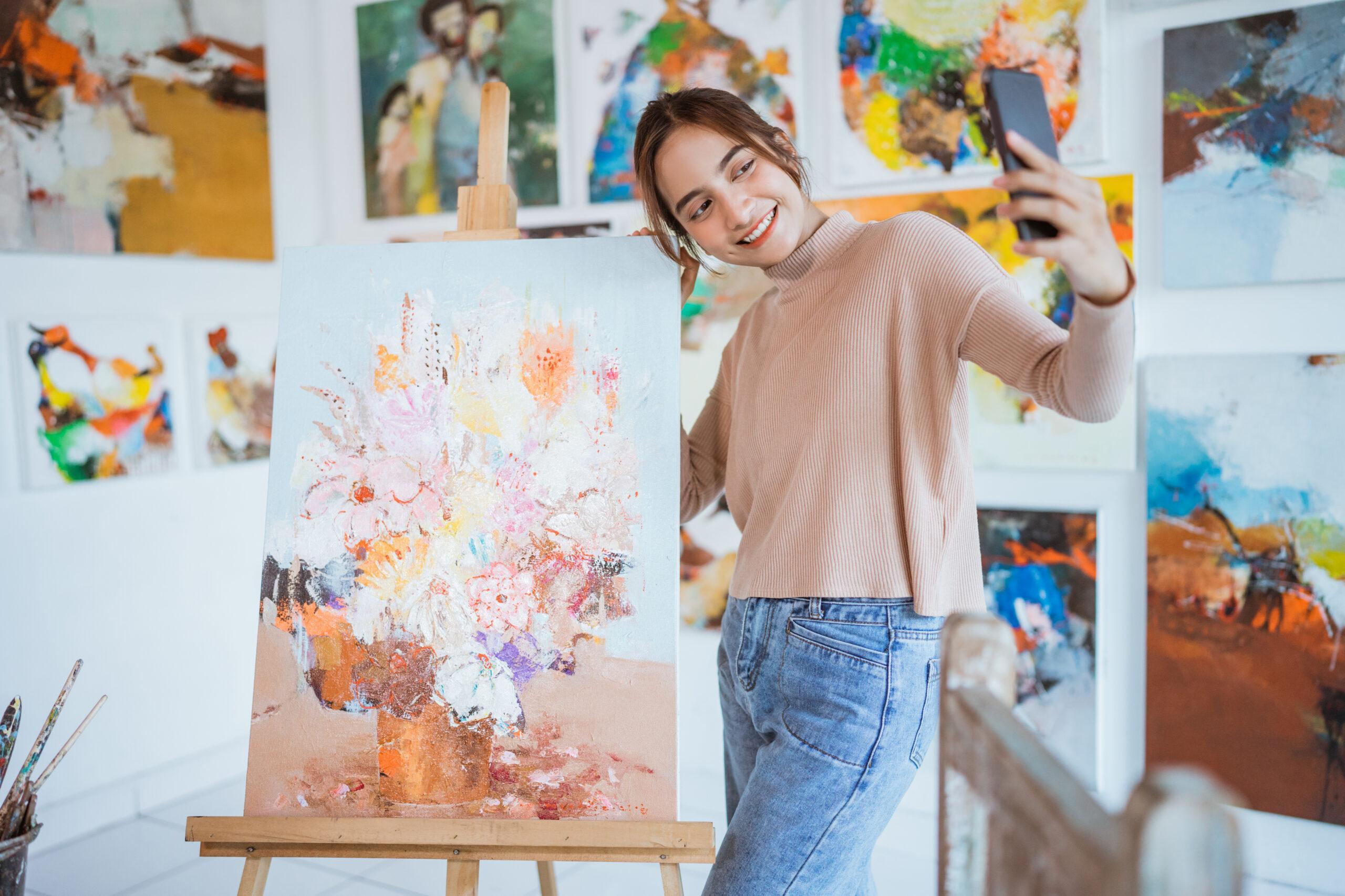 Artist taking a new Instagram selfie with her painting, wondering if she can delete her old photo from an Instagram post.