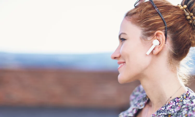 Young redhead woman with hands free device