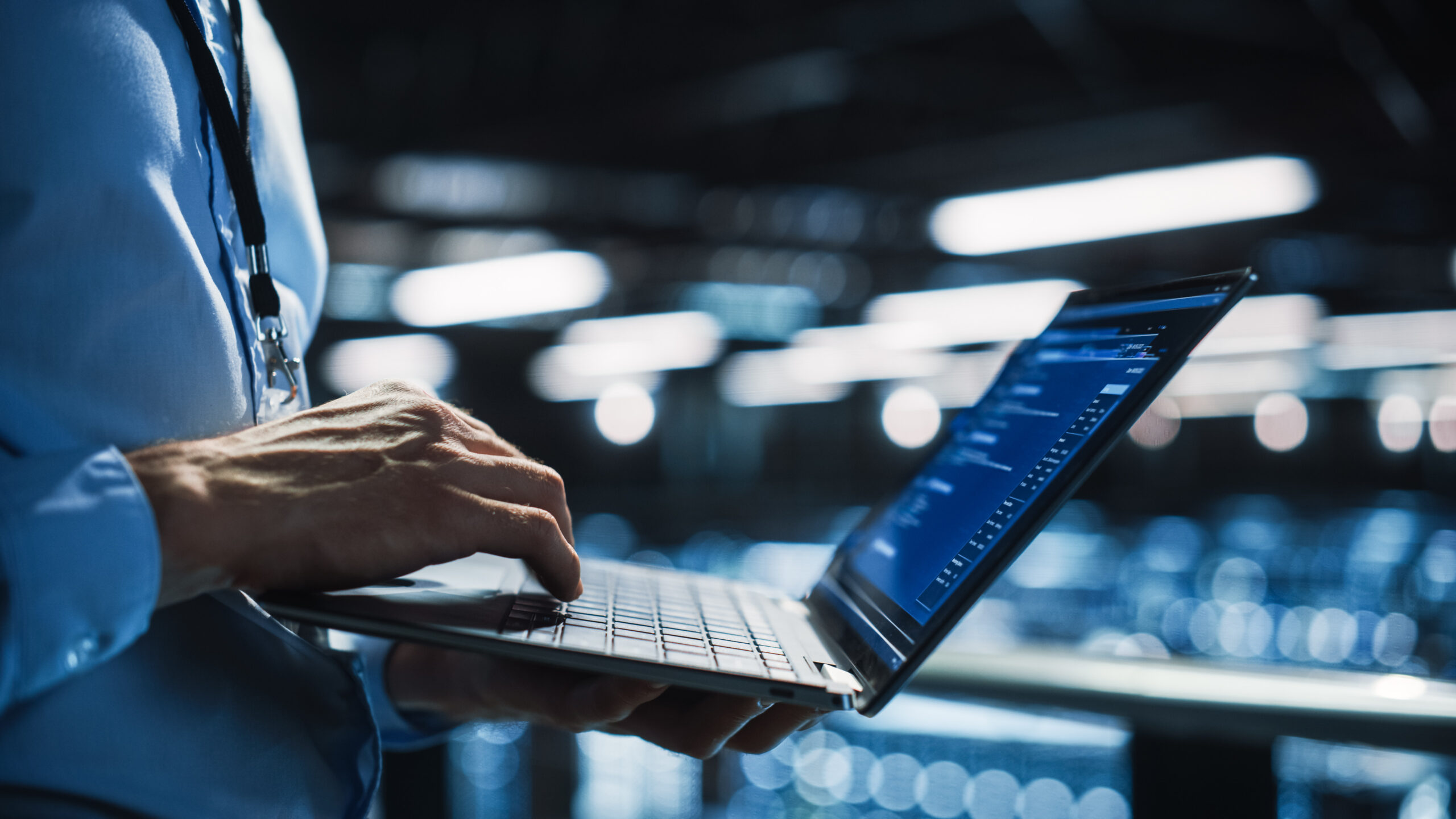 IT professional working on laptop at data center