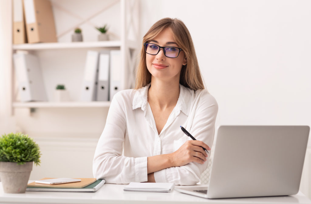 Confident woman with glasses working in her office