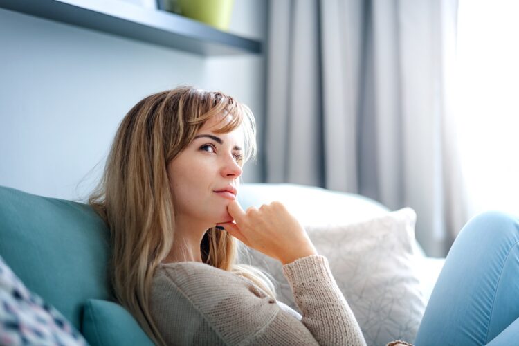 Woman at home deep in thoughts thinking