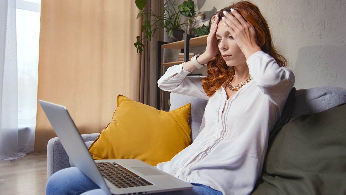 Upset young woman using laptop at home feels frustrated about computer problem