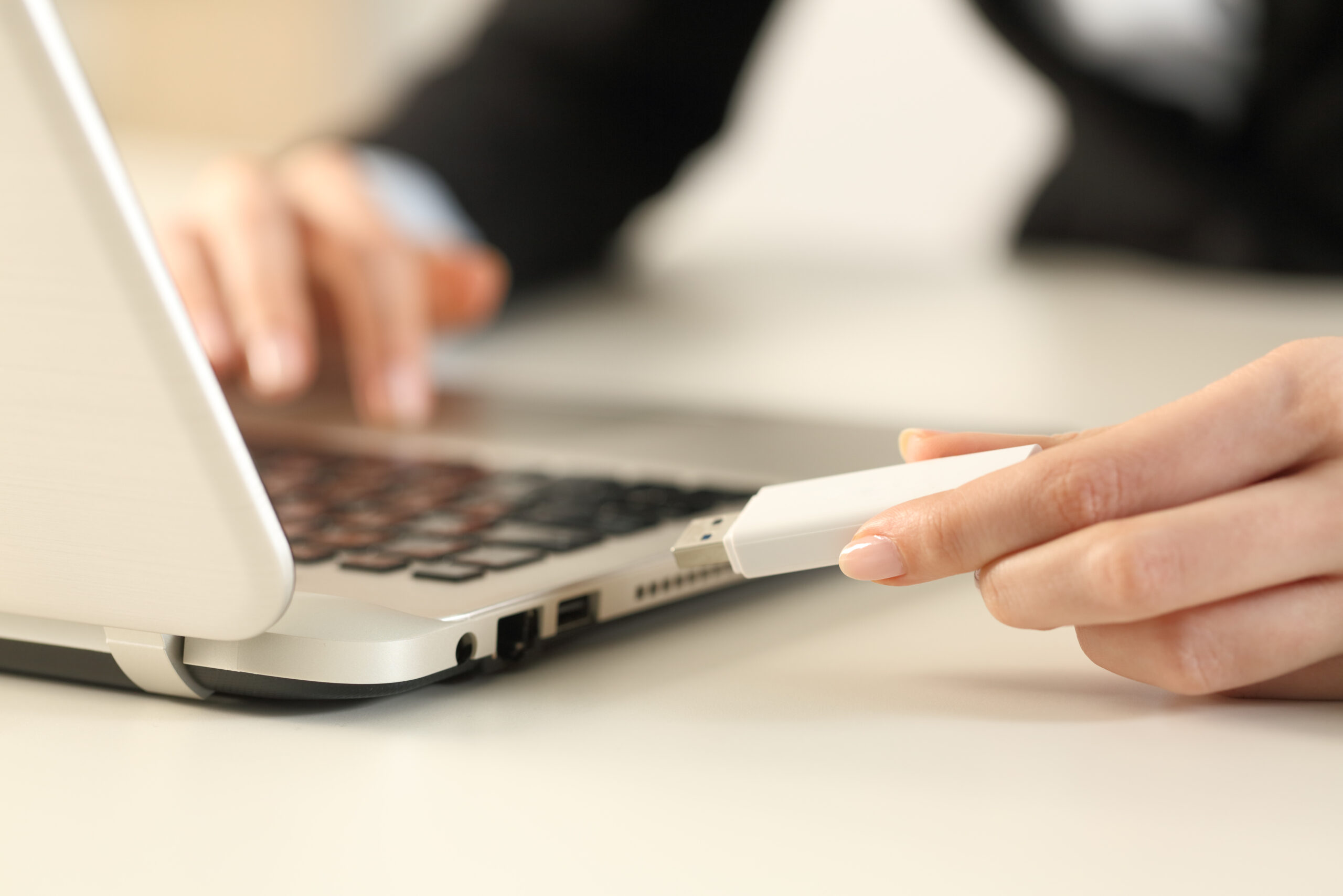 Executive hands plugging pendrive on laptop at office