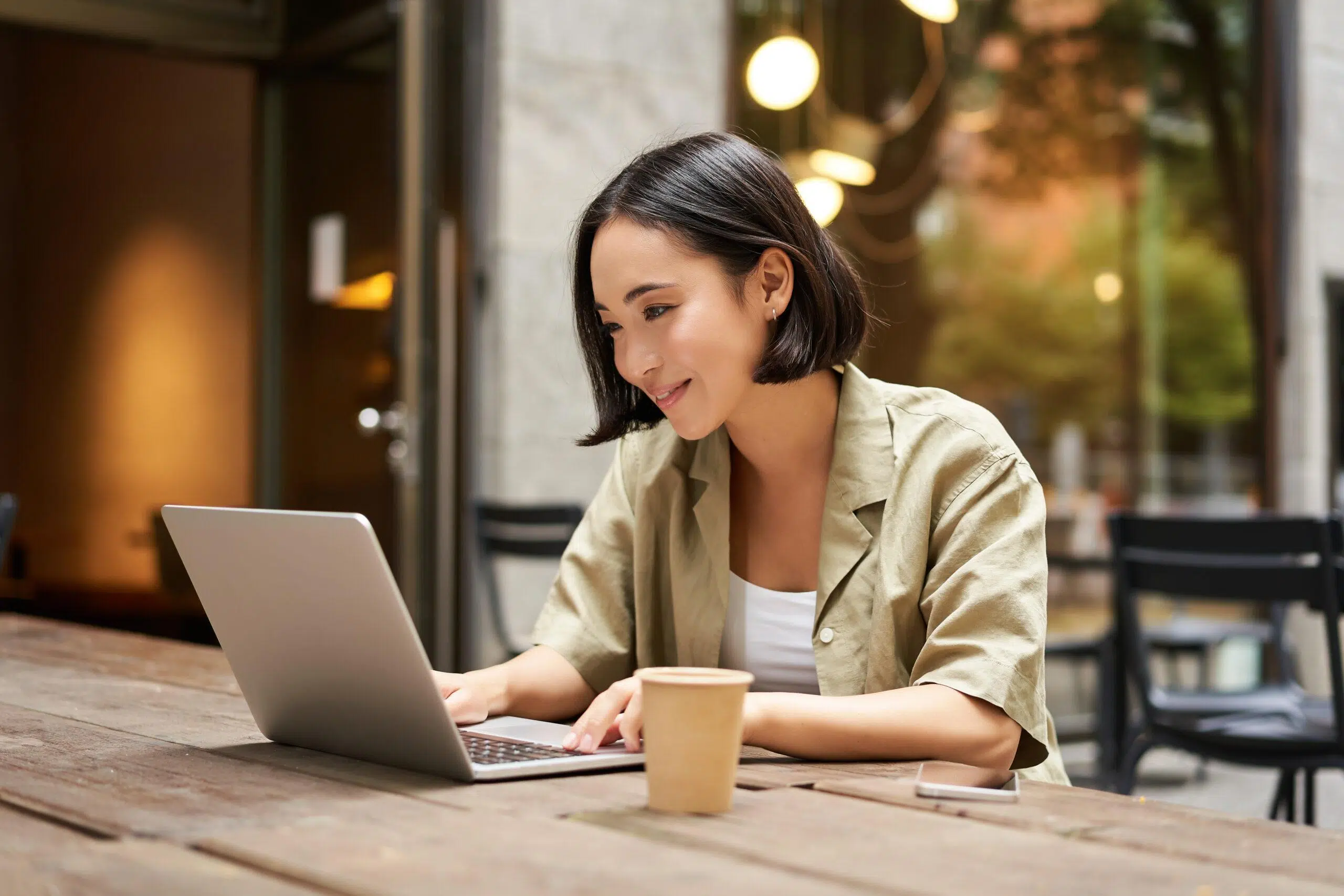 Young Asian woman working remotely from a cafe
