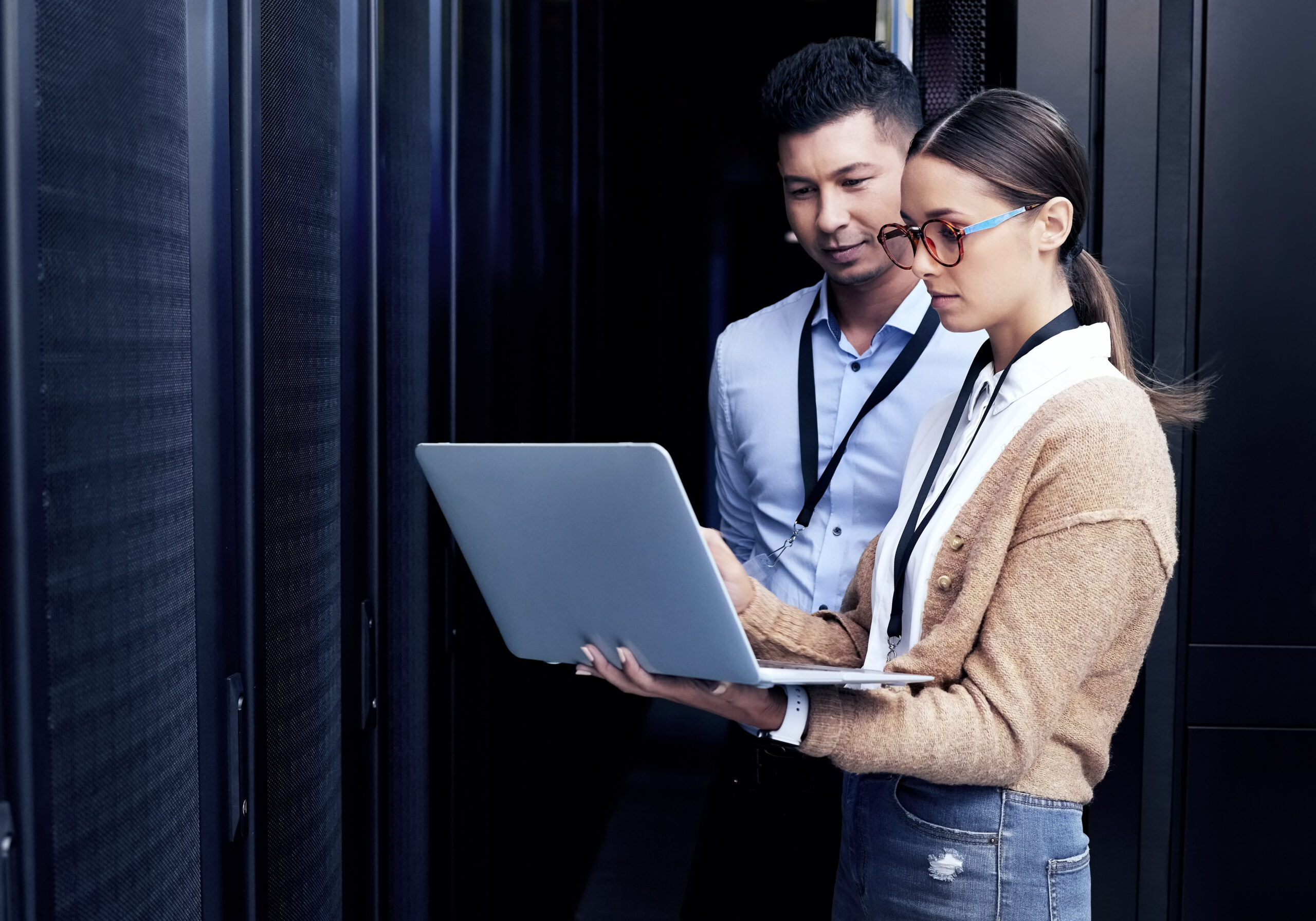 two IT technicians working together in a server room