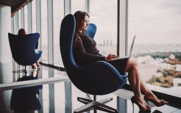 Businesswoman with laptop sitting by the window.