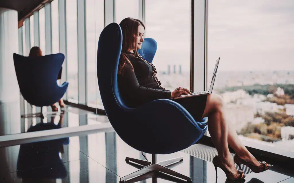 Businesswoman with laptop sitting by the window.