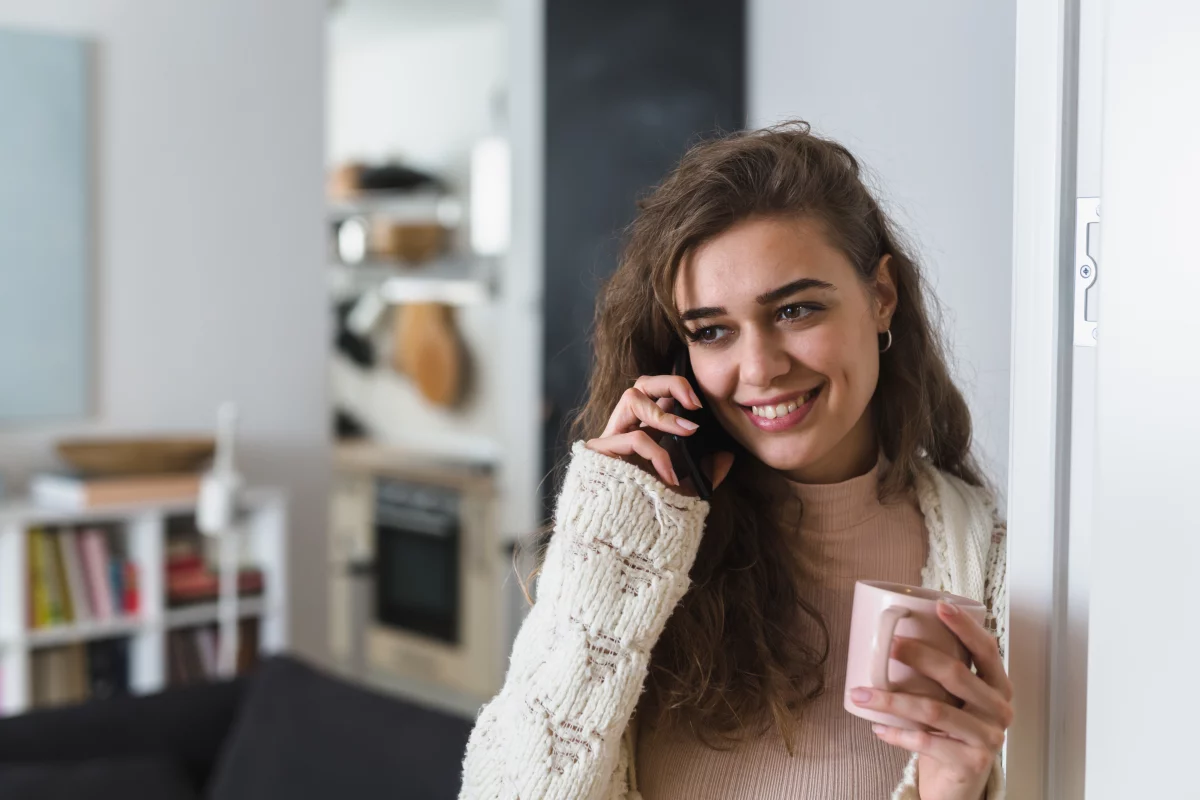 Attractive woman drinking coffee and talking on mobile phone