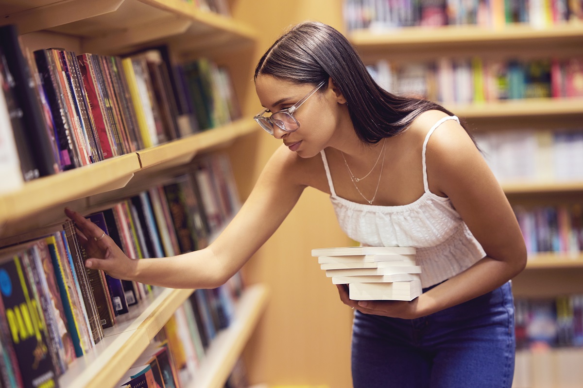 young attractive woman looking for books in the library