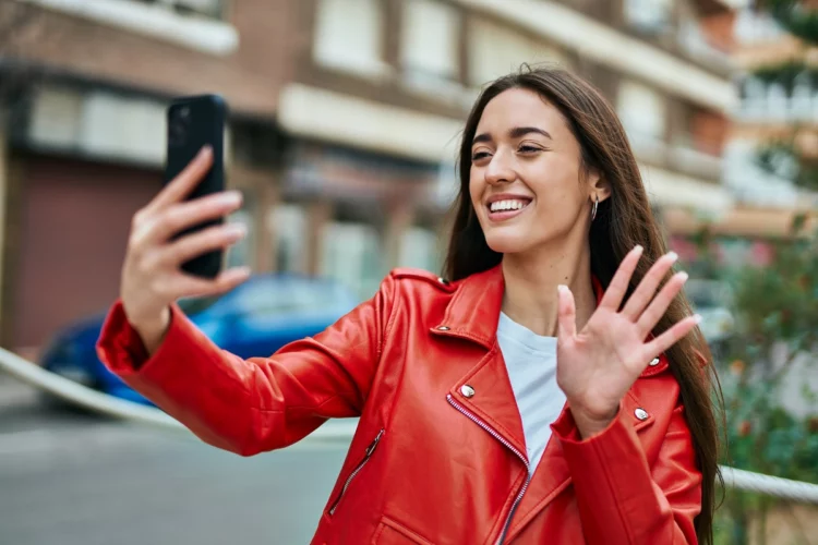 Young woman doing video call using smartphone at the city.