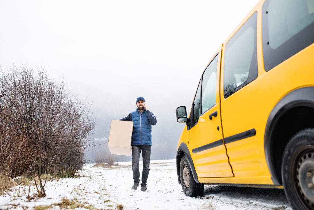 Delivery man attempting delivery of parcel.