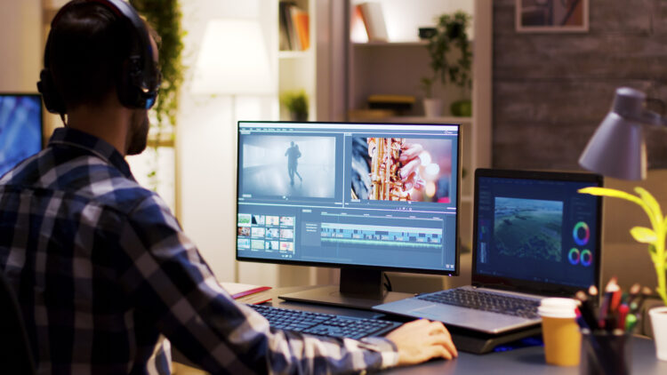 Film maker pointing at the monitor in home office