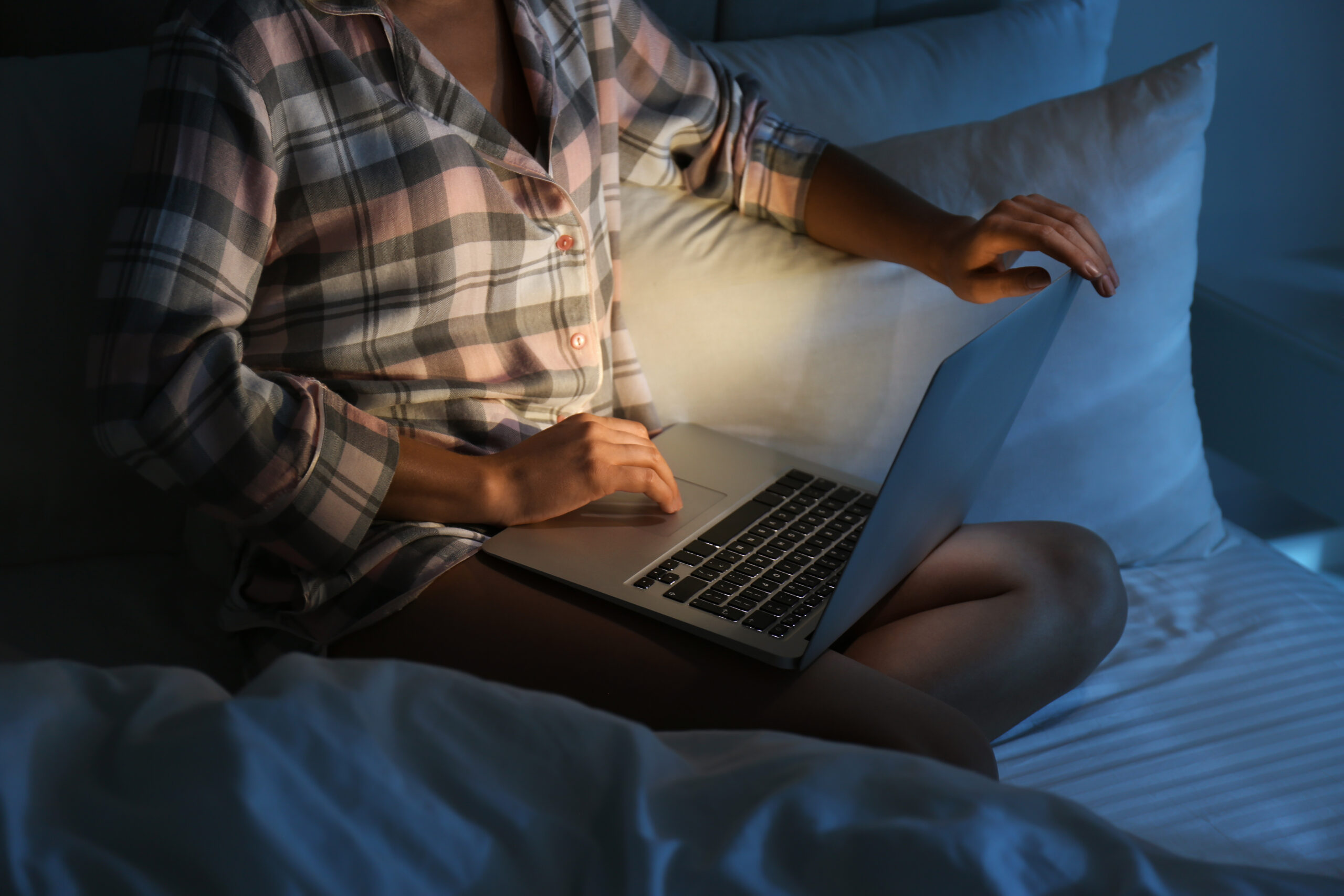 Woman using laptop in bed at night, closeup. Sleeping disorder p
