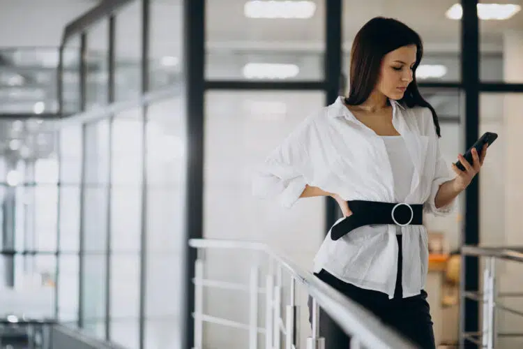 Young business woman using phone at the office