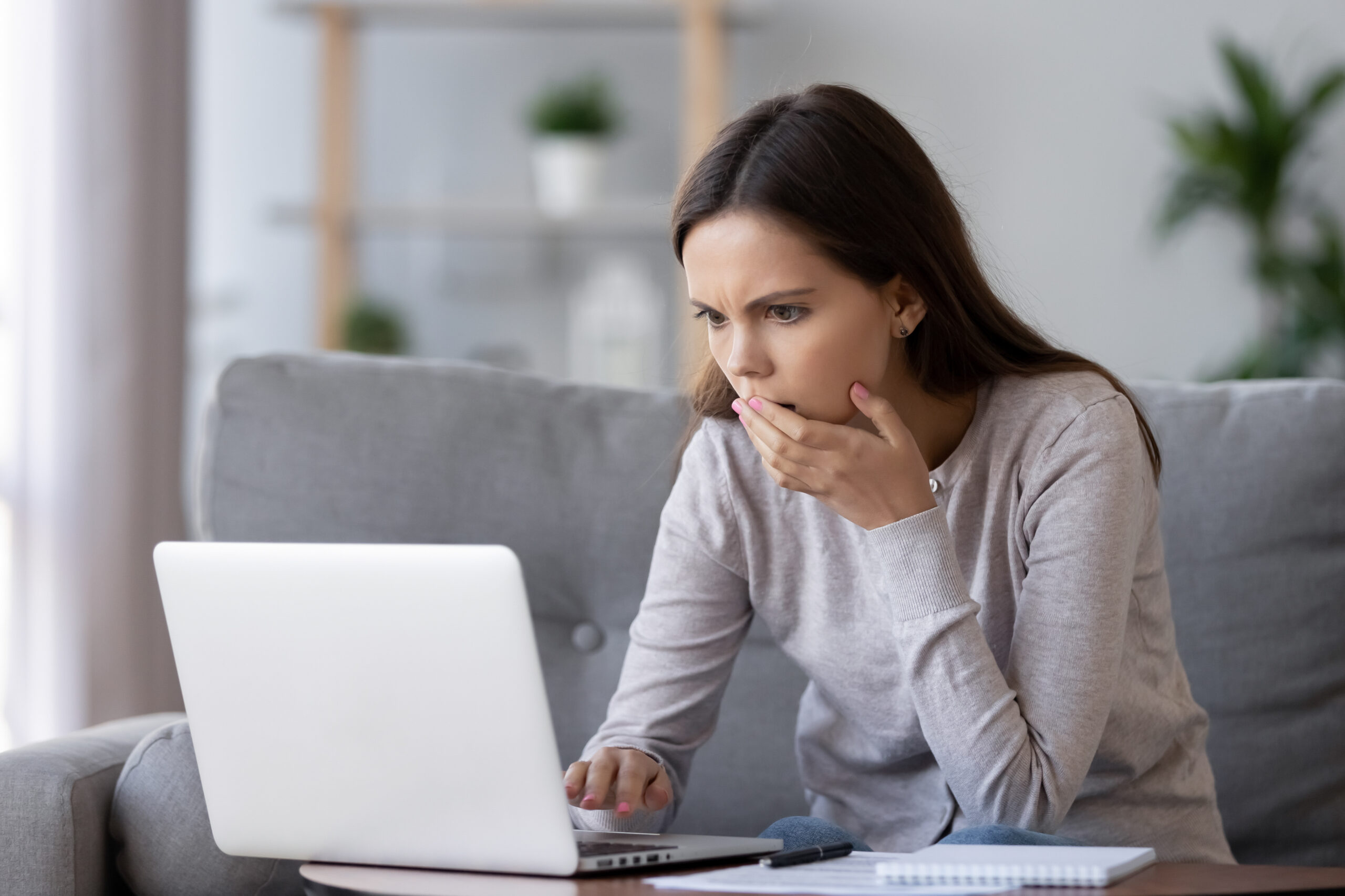 Shocked stressed woman reading bad news looking at laptop