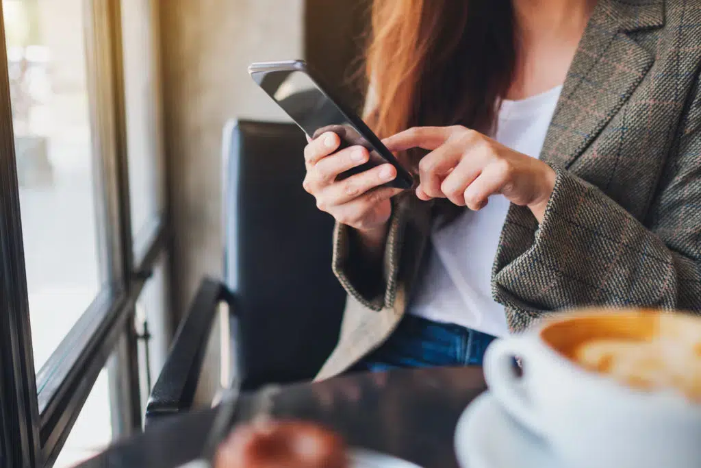 Woman at coffee shop using her mobile phone.