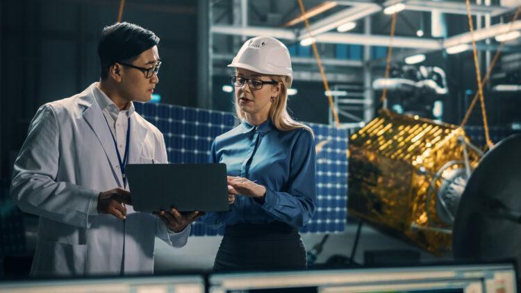 Engineer and technician working on satellite construction 