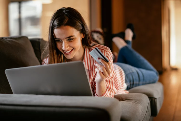 excited young woman at home makes a purchase on the Internet on the laptop