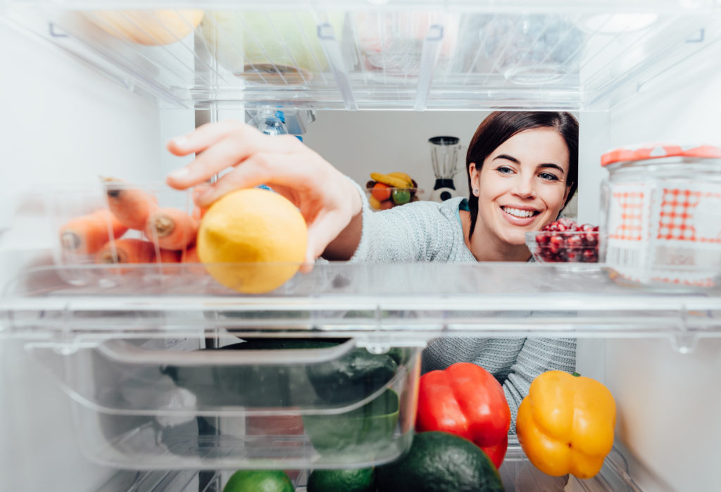 Woman taking a lemon out of the fridge