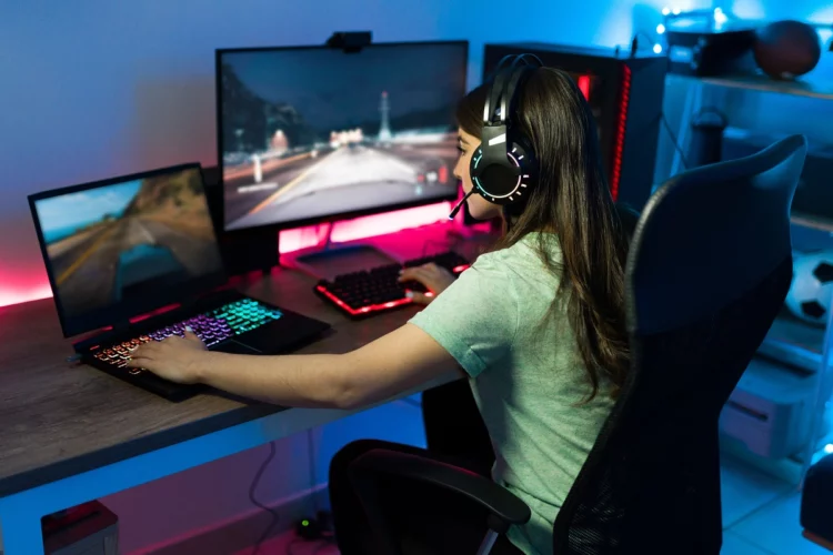 Professional female gamer playing with a PC and a laptop