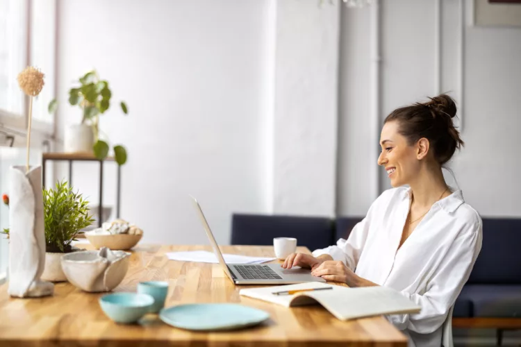 woman having coffee and working virtually from home