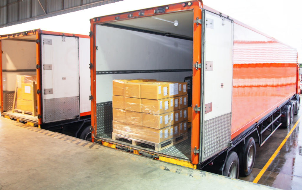 Package boxes loading into cargo truck.