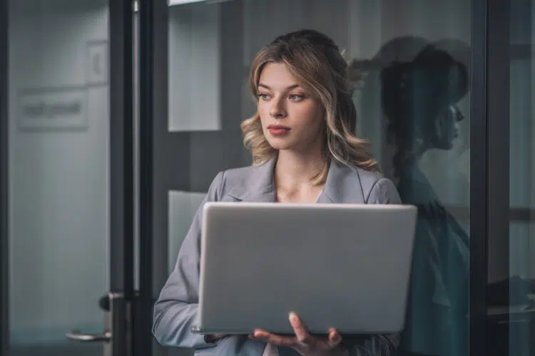 Woman on computer thinking about how to comment for better reach on a LinkedIn post