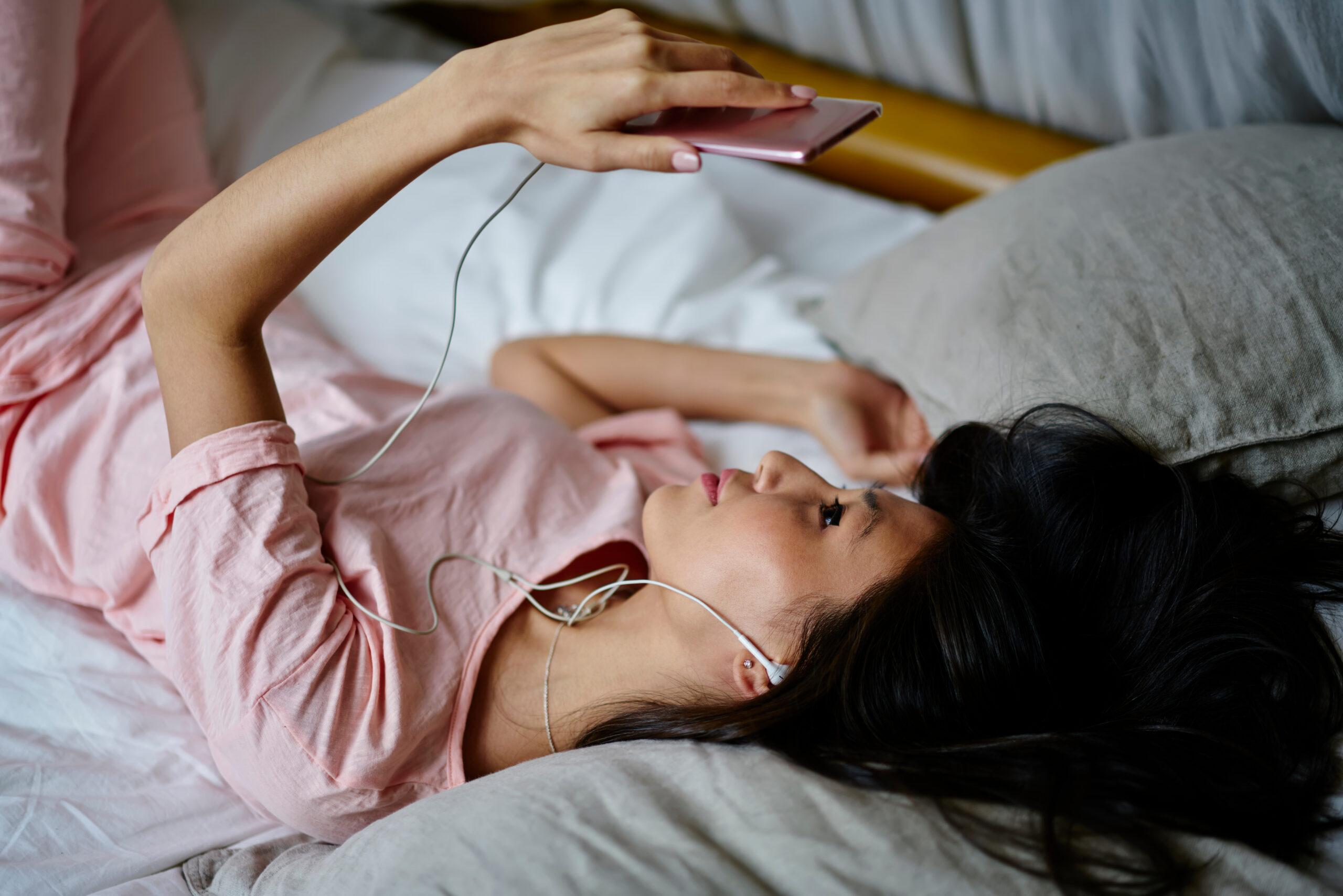 Asian woman in electronic headphones checking received email mes